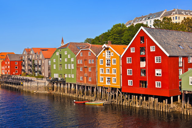 Solen skiner på färgglada träfasader i Trondheim, Norge.