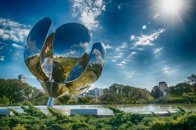Park i Buenos Aires med en stålskulptur av en blomma i förgrunden.