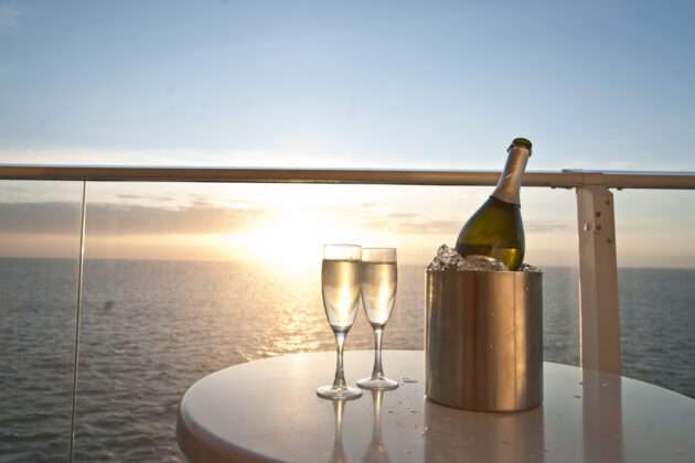 Uppdukat med bubbel till solnedgången sedd från balkongen på ett kryssningsfartyg.