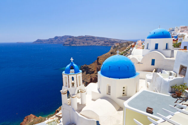 Vy över de vitkalkade husen med blå kupoltak som är så typiskt för Santorini, Grekland.