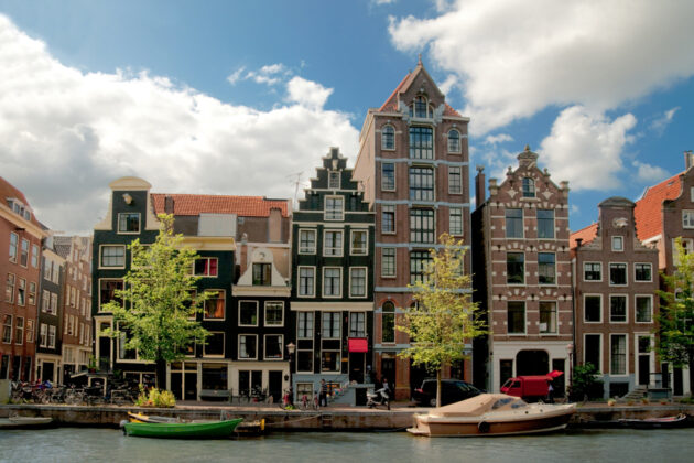 Vackra hus längs en kanal i Amsterdam, Nederländerna.